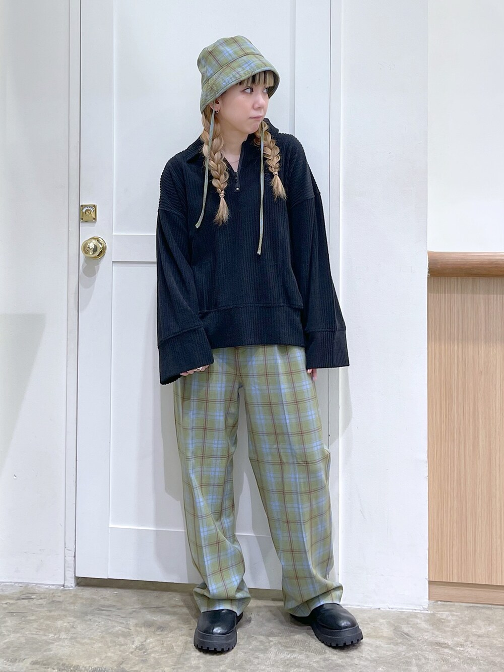 ブラック系のスウェット、グリーン系のその他パンツ、グリーン系のハットを着用したレディースの冬コーディネートの2枚目の写真