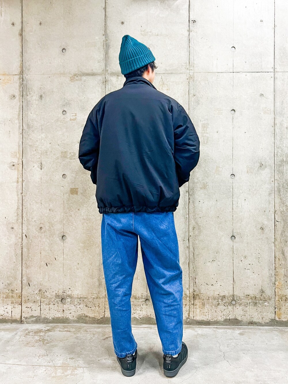 ブラック系のブルゾン、ブラック系のその他トップス、ブルー系のその他パンツを着用したメンズの冬コーディネートの2枚目の写真