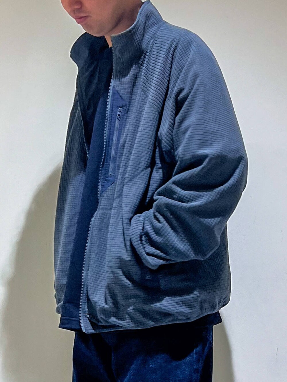 ブルー系のデニムパンツ、ブルー系のTシャツ/カットソー、グレー系のブルゾンを着用したメンズの秋コーディネートの4枚目の写真