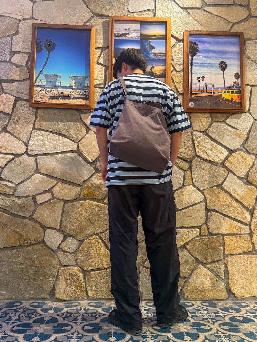 ブラック系のスニーカー、ブルー系のTシャツ/カットソー、グレー系のショルダーバッグを着用したメンズの春コーディネートの3枚目の写真