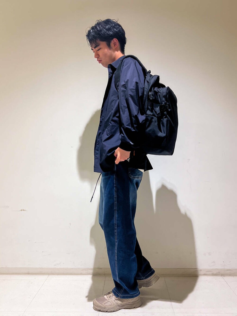 グリーン系のスニーカー、ブルー系のデニムパンツ、ブラック系のシャツ/ブラウスを着用したメンズの秋コーディネートの2枚目の写真