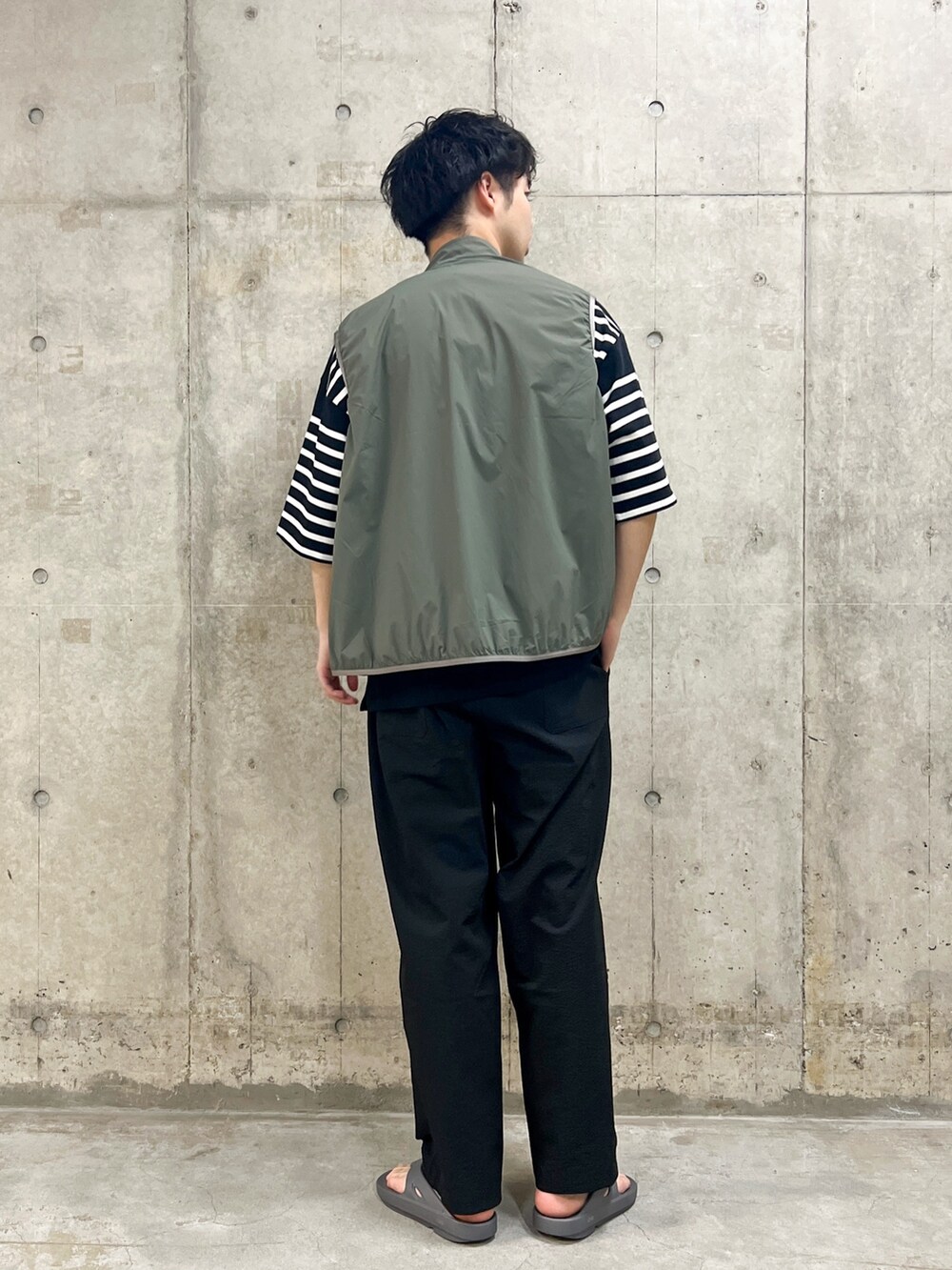 グリーン系のベスト、ブラック系のTシャツ/カットソー、ブラック系のその他パンツを着用したメンズの夏コーディネートの2枚目の写真