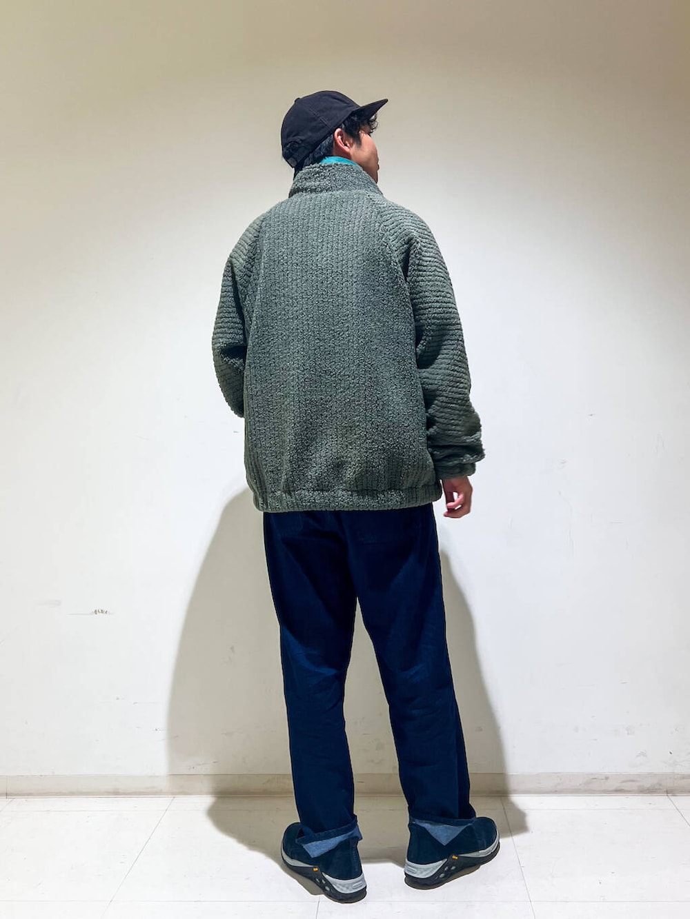 ブルー系のデニムパンツ、ベージュ系のTシャツ/カットソー、グリーン系のブルゾンを着用したメンズの秋コーディネートの3枚目の写真