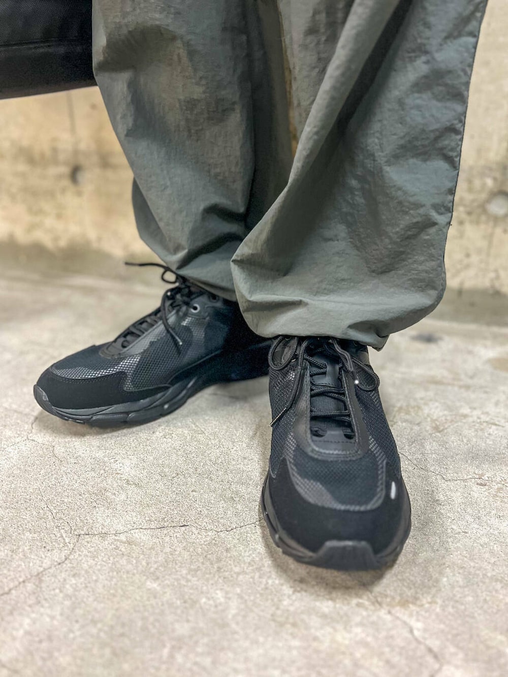 グレー系のその他パンツ、ブラック系のトートバッグ、ベージュ系のTシャツ/カットソーを着用したメンズの秋コーディネートの5枚目の写真