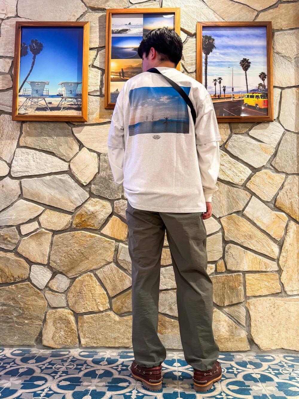 レッド系のモカシン/デッキシューズ、グレー系のTシャツ/カットソー、グリーン系のショルダーバッグを着用したメンズの春コーディネートの4枚目の写真