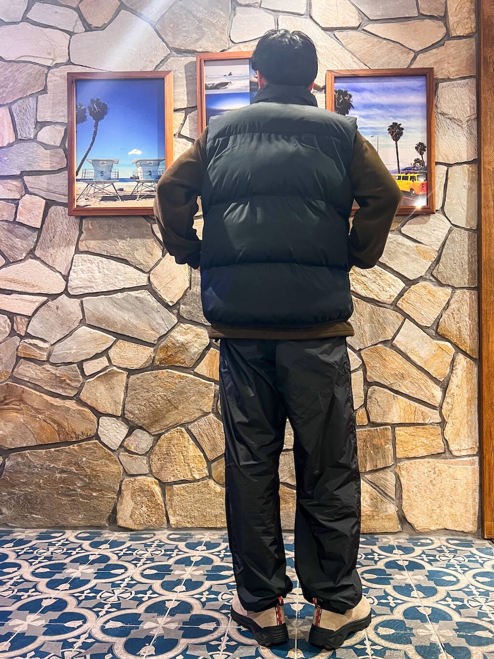 グリーン系のスウェット、ブラック系のダウンベストを着用したメンズの冬コーディネートの2枚目の写真