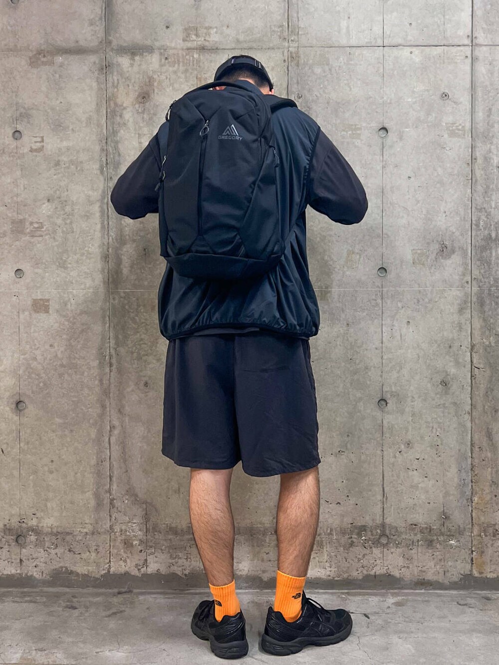 グレー系のTシャツ/カットソー、ブラック系のベスト、ブラック系のバックパック/リュックを着用したメンズの秋コーディネートの3枚目の写真