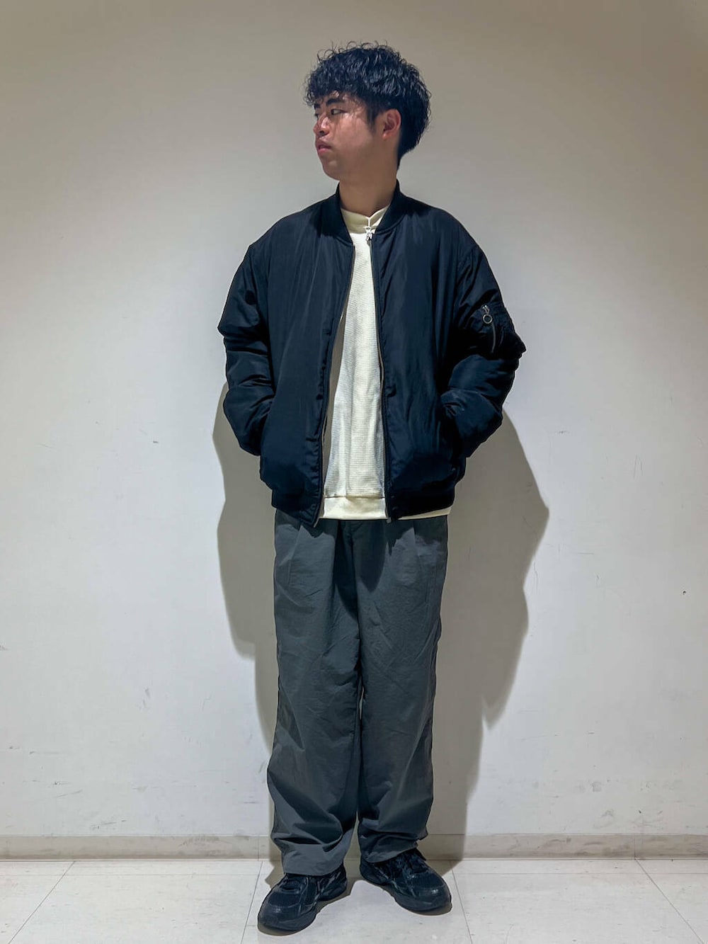 グレー系のその他パンツ、ホワイト系のTシャツ/カットソー、ブラック系のMA-1を着用したメンズの秋コーディネートの2枚目の写真