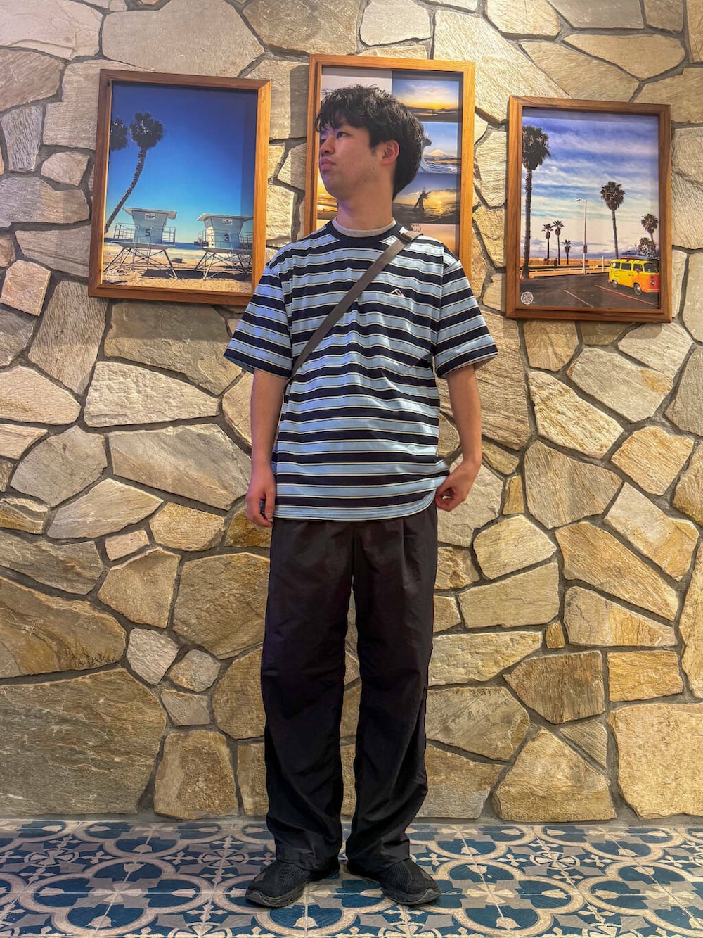 ブラック系のスニーカー、ブルー系のTシャツ/カットソー、グレー系のショルダーバッグを着用したメンズの春コーディネートの2枚目の写真