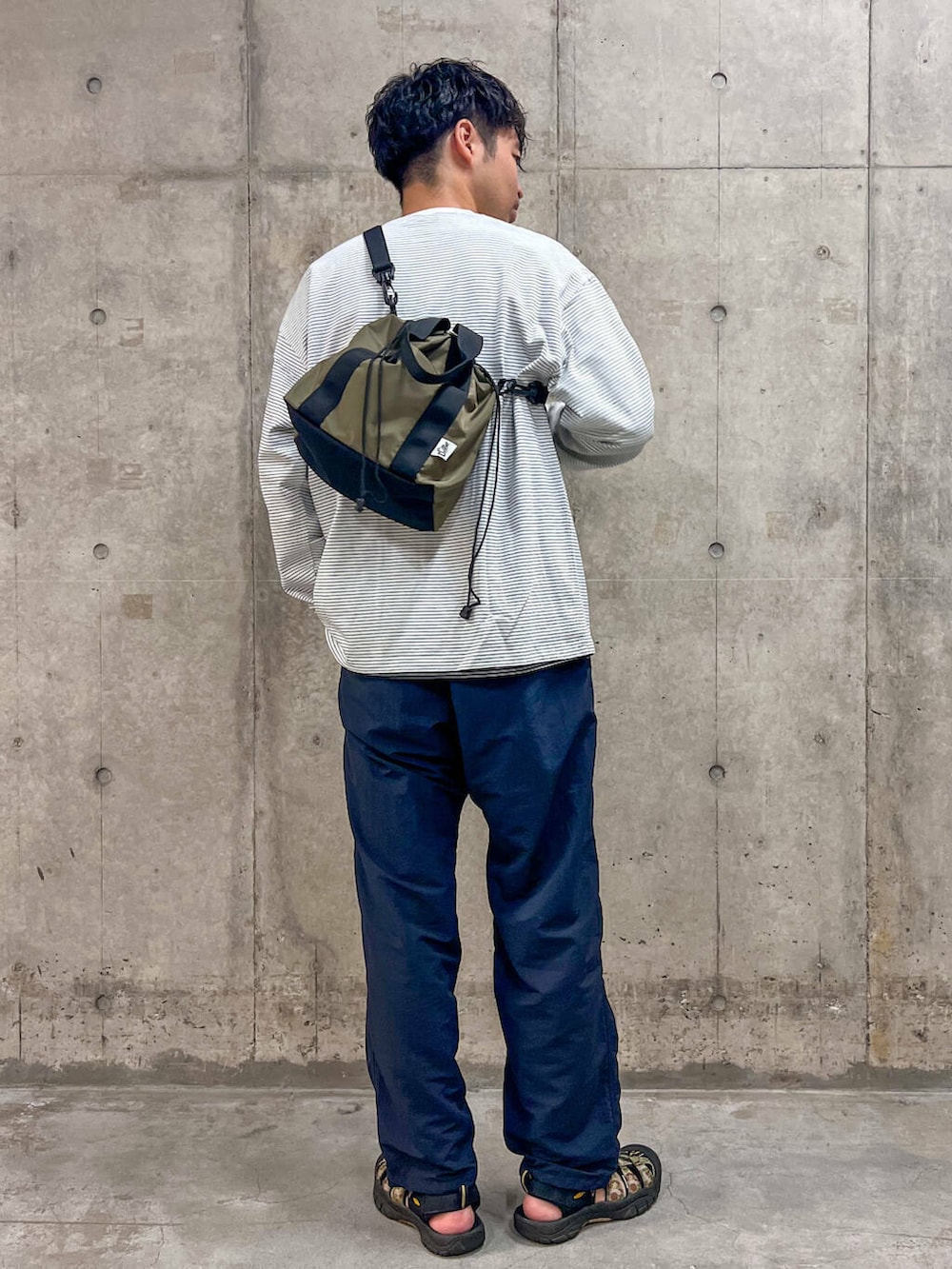 ブルー系のその他パンツ、ブラウン系のトートバッグ、ホワイト系のTシャツ/カットソーを着用したメンズの秋コーディネートの4枚目の写真