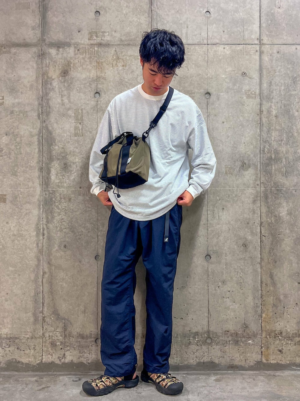 ブルー系のその他パンツ、ブラウン系のトートバッグ、ホワイト系のTシャツ/カットソーを着用したメンズの秋コーディネートの2枚目の写真