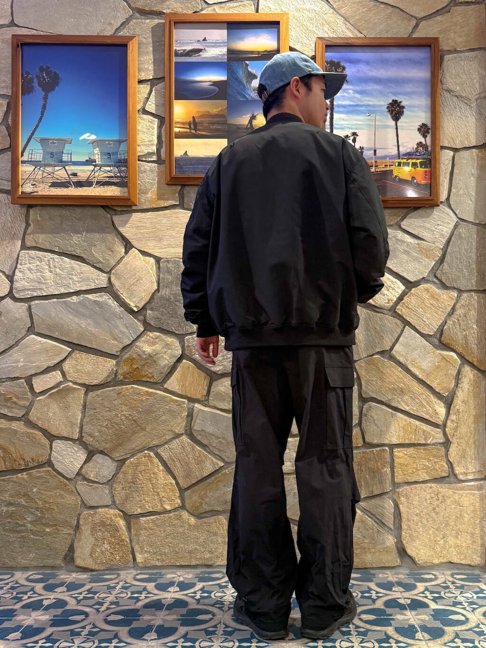 グレー系のTシャツ/カットソー、ブラック系のMA-1、ブルー系のキャップを着用したメンズの春コーディネートの2枚目の写真