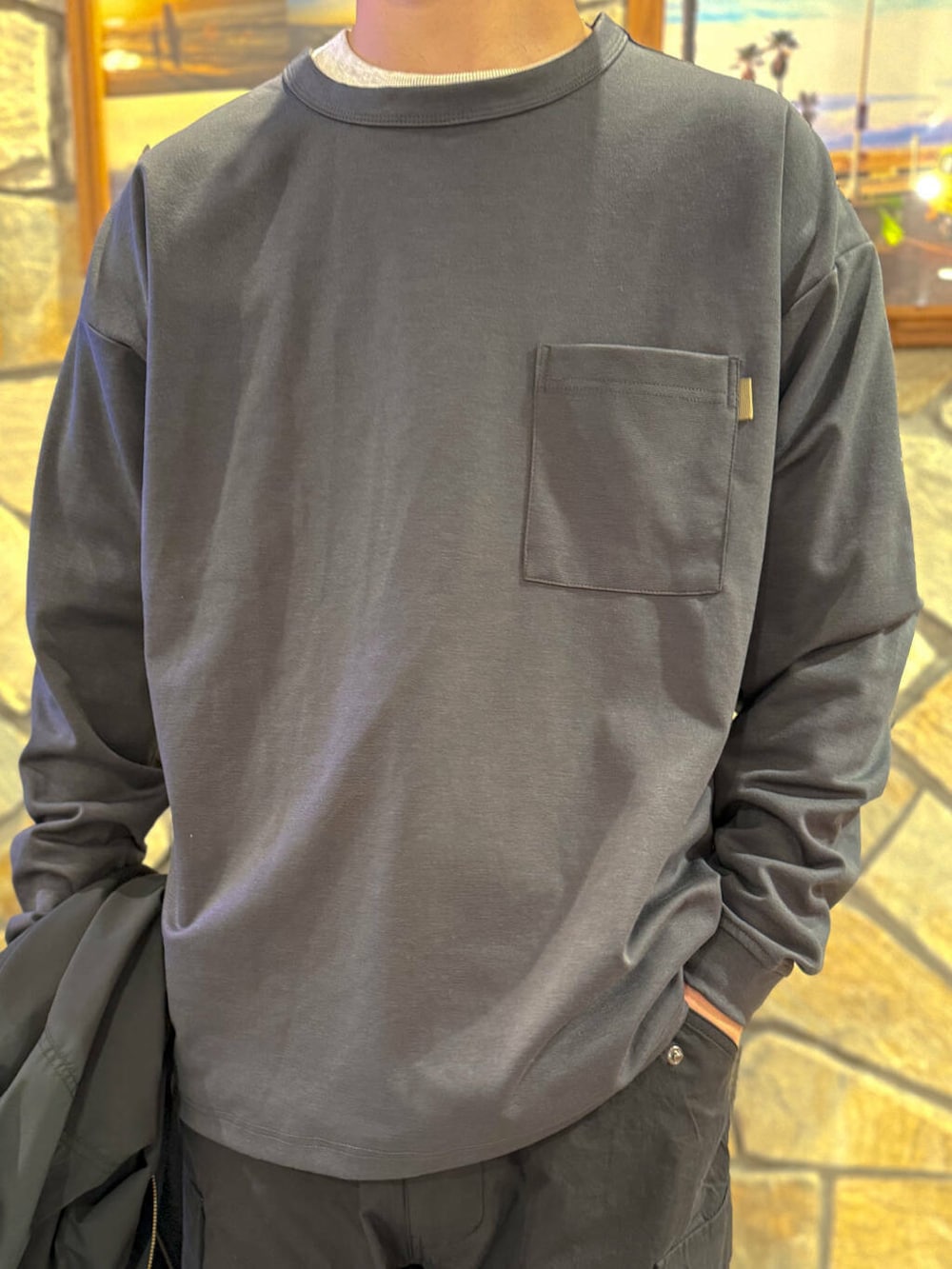 グレー系のTシャツ/カットソー、ブラック系のMA-1、ブルー系のキャップを着用したメンズの春コーディネートの4枚目の写真