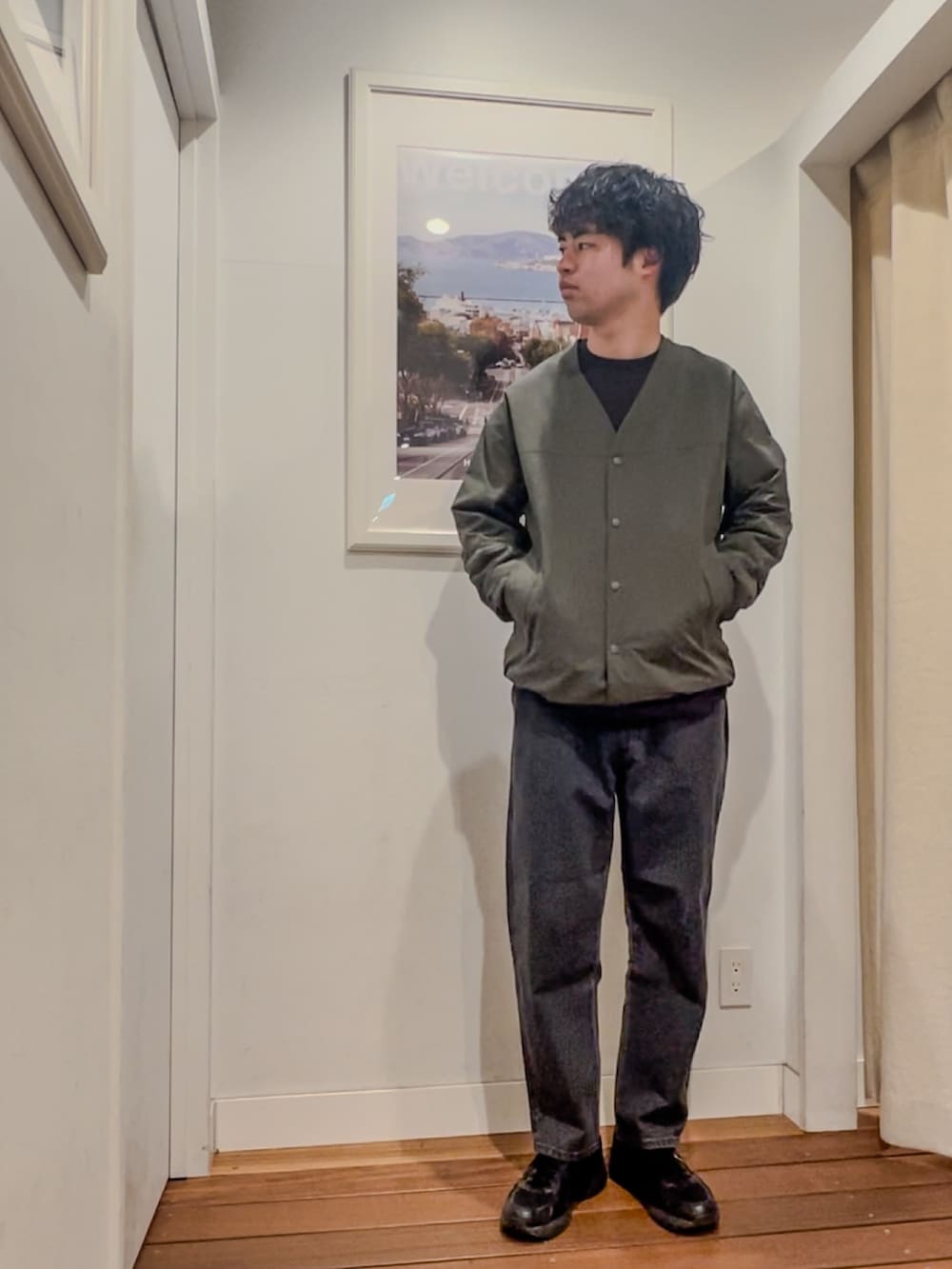 グリーン系のカーディガン/ボレロ、グレー系のTシャツ/カットソー、ブラック系のデニムパンツを着用したメンズの春コーディネートの2枚目の写真