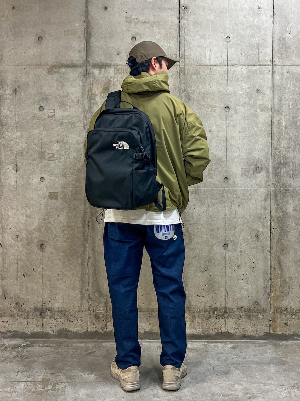 ブラック系のバックパック/リュック、グリーン系のマウンテンパーカー、グリーン系のキャップを着用したメンズの春コーディネートの2枚目の写真