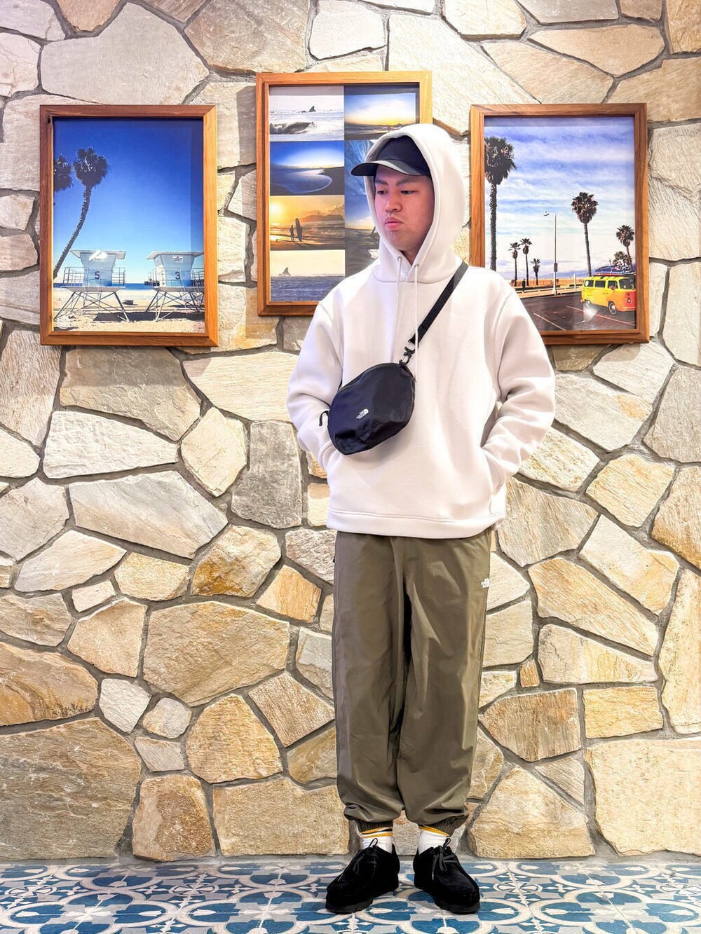 ブラック系のブーツ、グリーン系のその他パンツ、グレー系のショルダーバッグを着用したメンズの春コーディネートの2枚目の写真