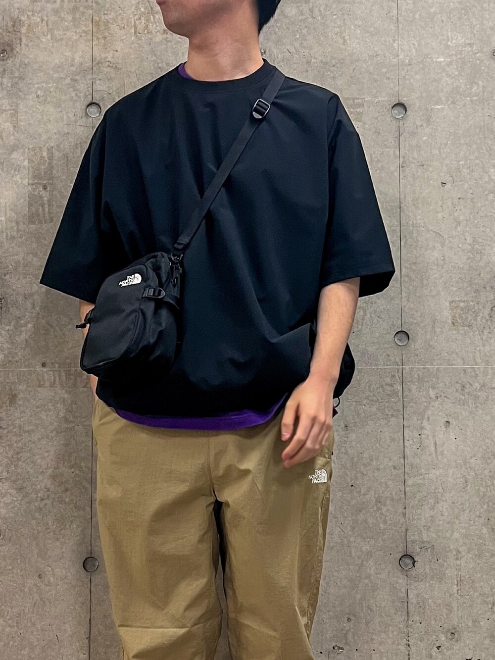 ブラック系のTシャツ/カットソー、ブラック系のショルダーバッグ、ベージュ系のその他パンツを着用したメンズの春コーディネートの2枚目の写真