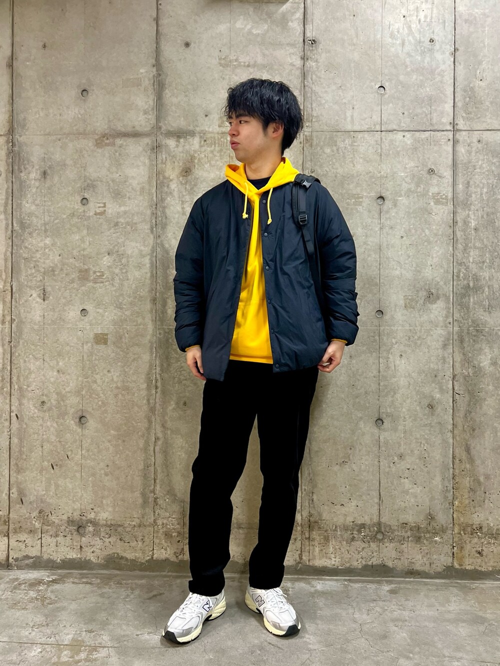 ブラック系のその他パンツ、ブラック系のバックパック/リュック、ブラウン系のダウンジャケット/コートを着用したメンズの冬コーディネートの2枚目の写真