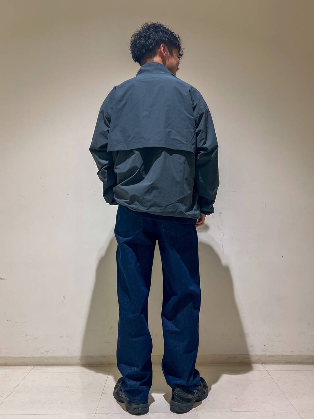 ブルー系のデニムパンツ、ブルー系のTシャツ/カットソー、グレー系のブルゾンを着用したメンズの秋コーディネートの2枚目の写真