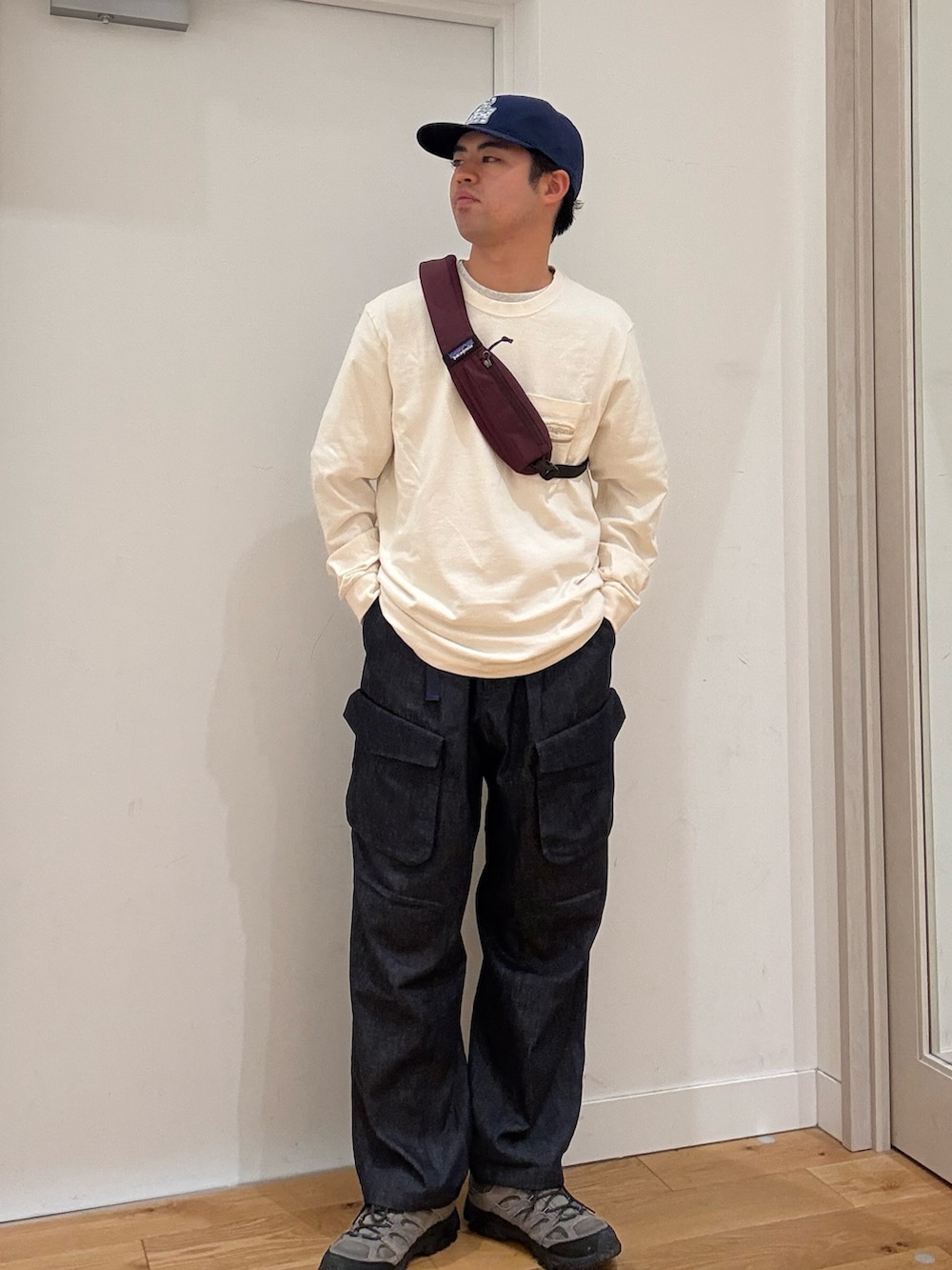 レッド系のショルダーバッグ、ホワイト系のTシャツ/カットソー、グレー系のスニーカーを着用したメンズの秋コーディネートの2枚目の写真