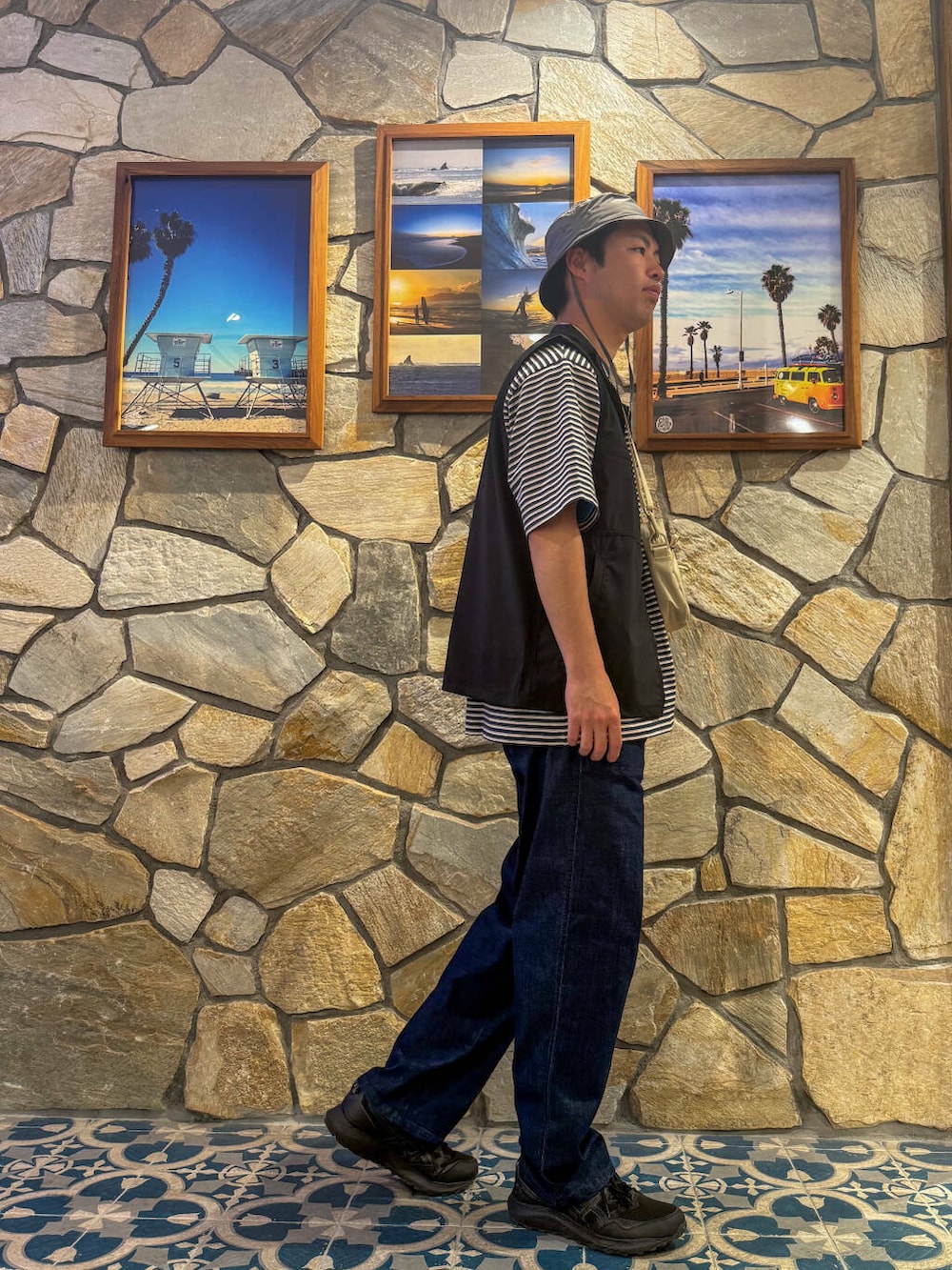 ブラック系のベスト、ベージュ系のショルダーバッグ、ブルー系のその他パンツを着用したメンズの春コーディネートの3枚目の写真