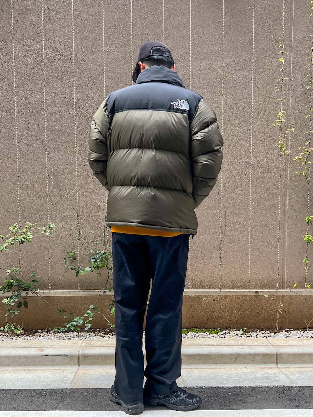 ブラック系のその他パンツ、イエロー系のTシャツ/カットソー、ブラック系のダウンジャケット/コートを着用したメンズの秋コーディネートの3枚目の写真