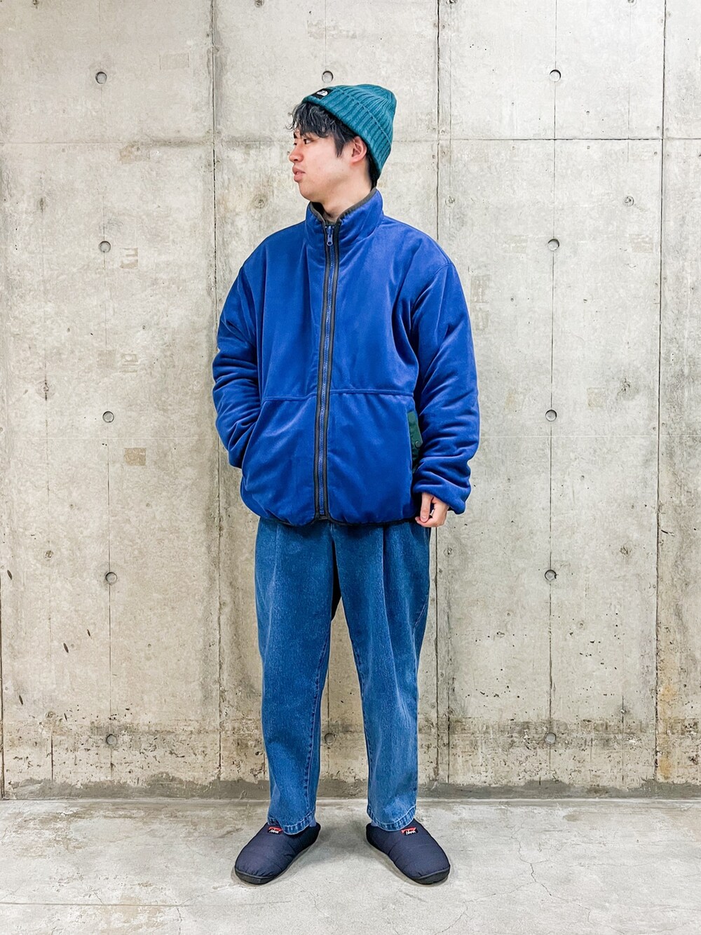 グリーン系のブルゾン、ブルー系のその他パンツ、ブルー系のサンダルを着用したメンズの冬コーディネートの3枚目の写真