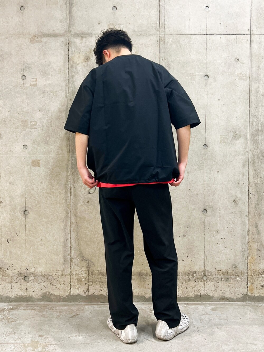ブラック系のTシャツ/カットソー、ブラック系のその他パンツ、レッド系のTシャツ/カットソーを着用したメンズの春コーディネートの2枚目の写真