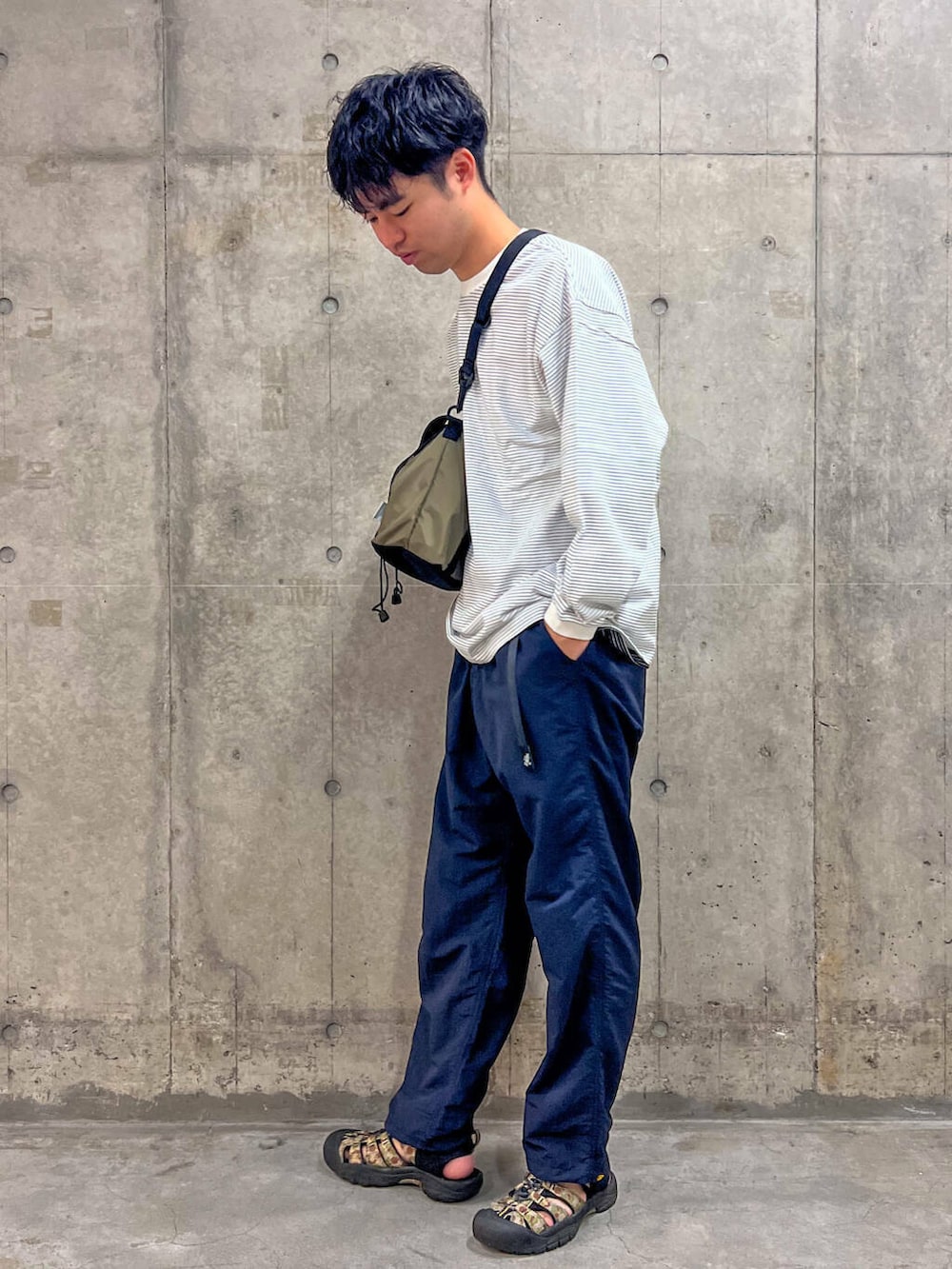 ブルー系のその他パンツ、ブラウン系のトートバッグ、ホワイト系のTシャツ/カットソーを着用したメンズの秋コーディネートの3枚目の写真