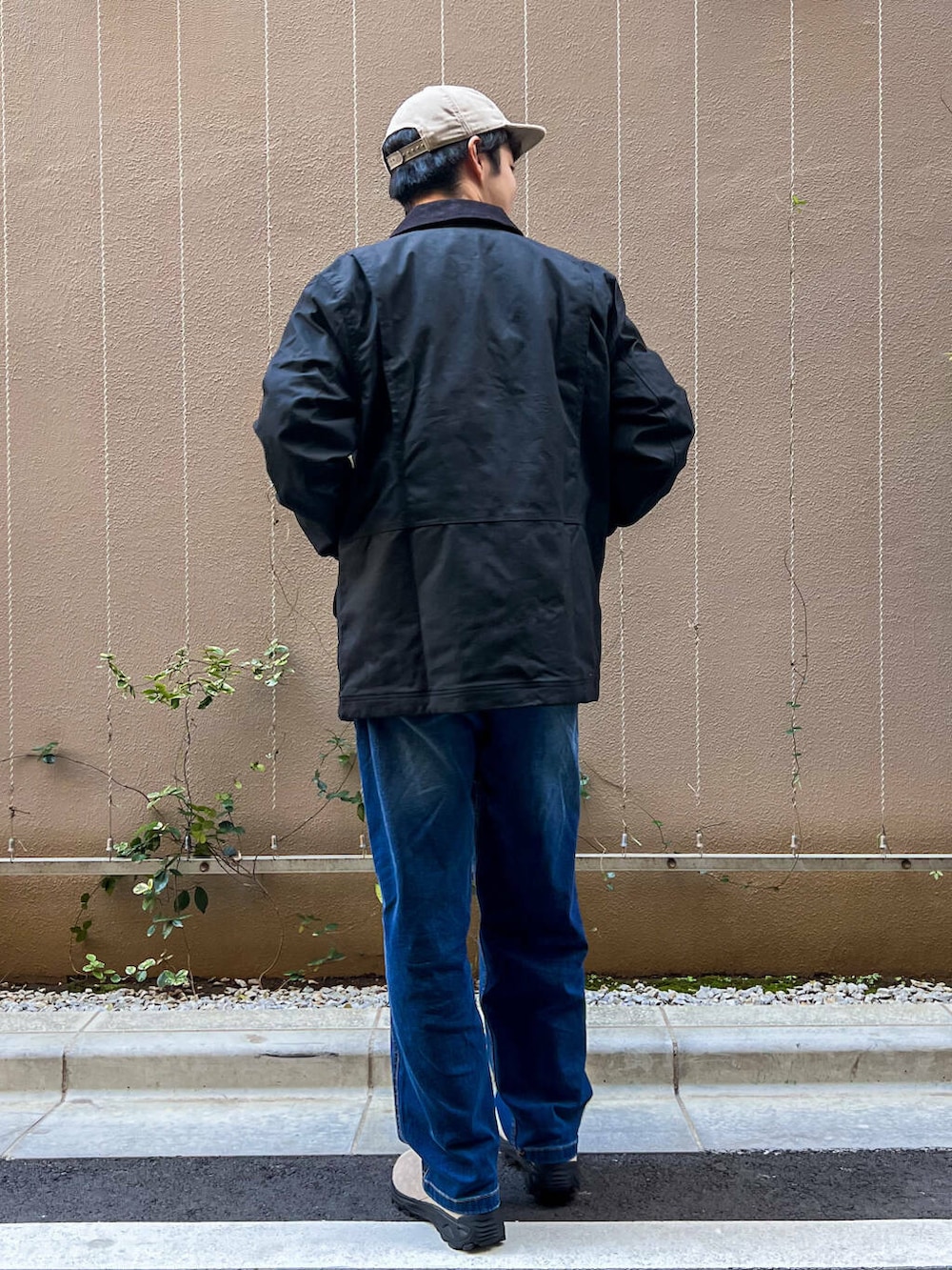 ブルー系のデニムパンツ、ホワイト系のスウェット、ブラック系のテーラードジャケットを着用したメンズの冬コーディネートの2枚目の写真