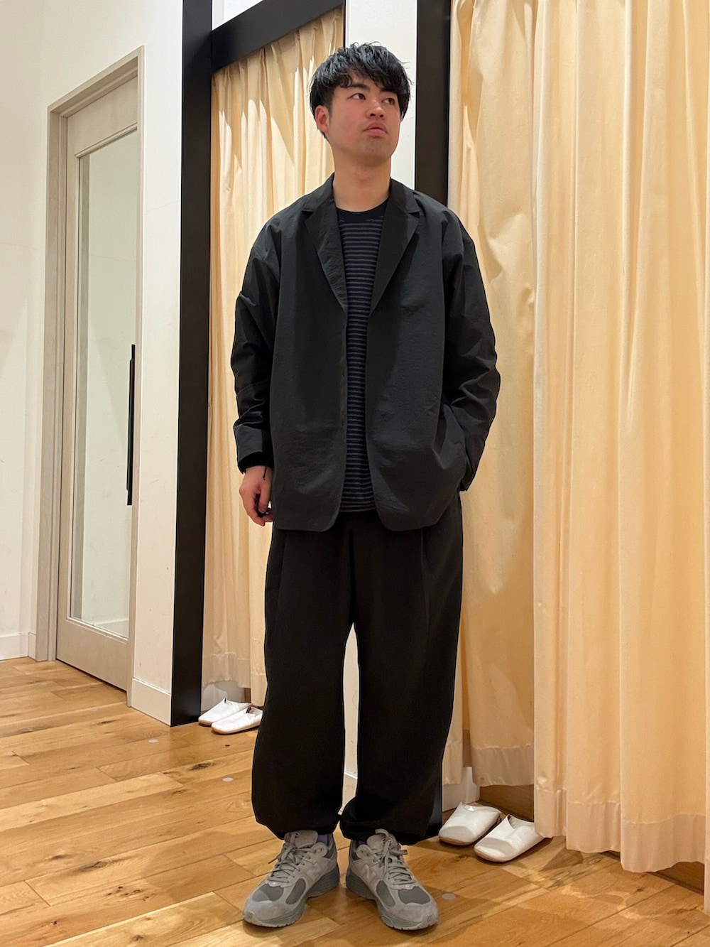 ブラック系のその他アウター、ブラック系のその他パンツ、ブルー系のTシャツ/カットソーを着用したメンズの春コーディネートの2枚目の写真