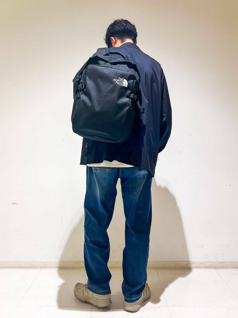 グリーン系のスニーカー、ブルー系のデニムパンツ、ブラック系のシャツ/ブラウスを着用したメンズの秋コーディネートの4枚目の写真