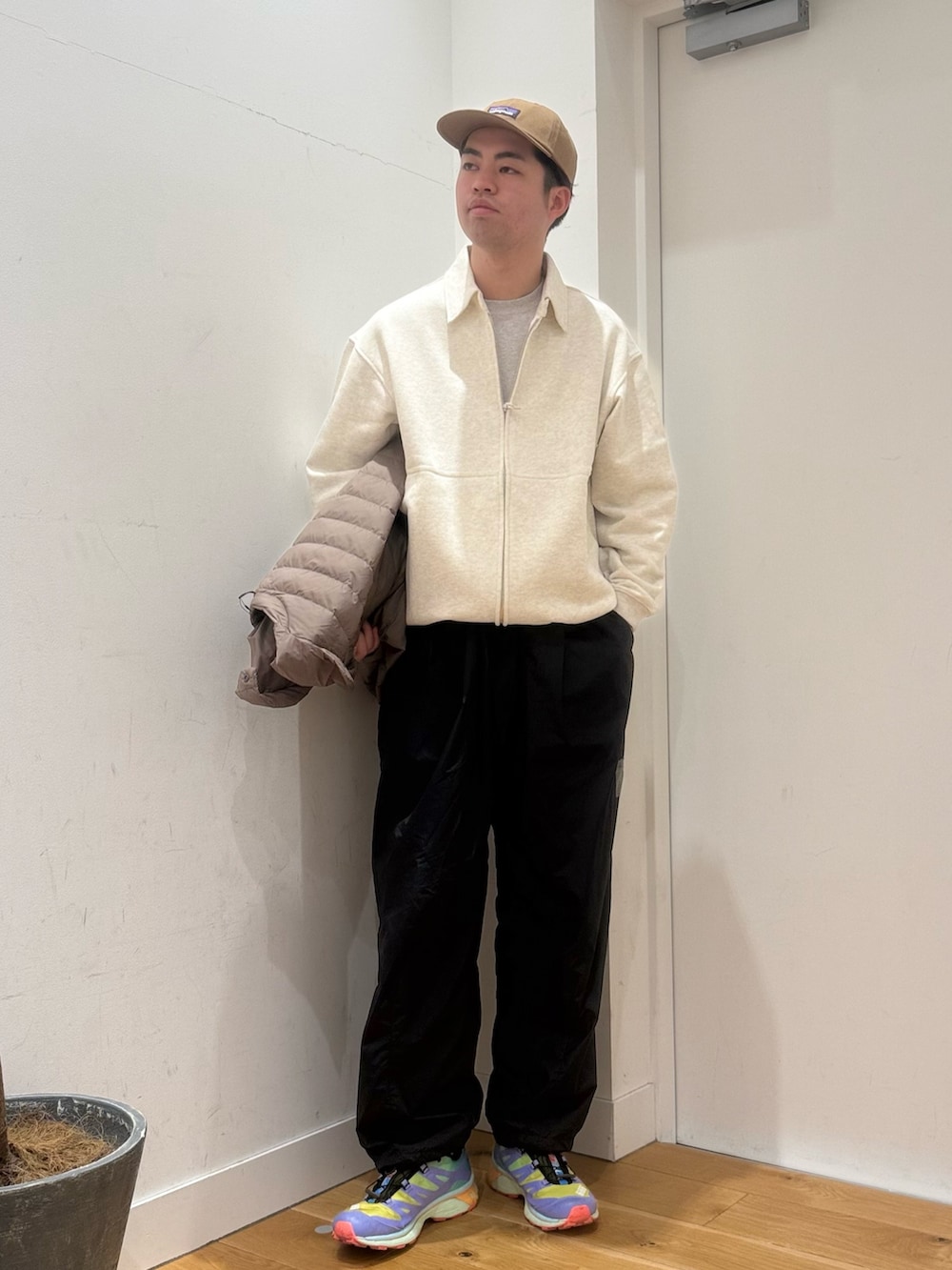 ブラウン系のダウンジャケット/コート、ベージュ系のカーディガン/ボレロ、ブラック系のその他パンツを着用したメンズの冬コーディネートの2枚目の写真