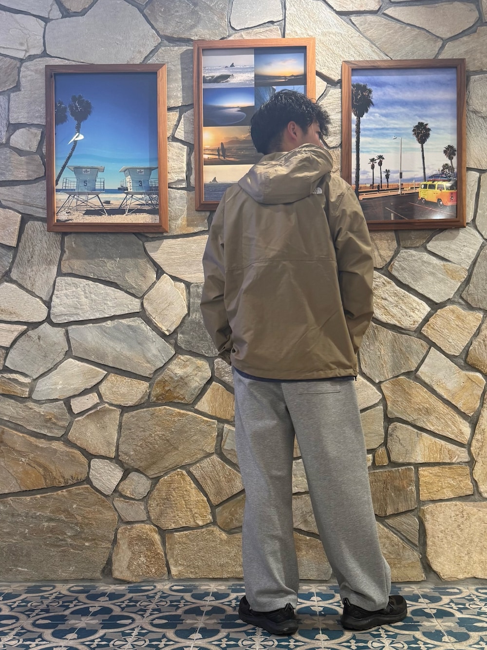 グリーン系のナイロンジャケット、グレー系のその他パンツを着用したメンズの秋コーディネートの2枚目の写真