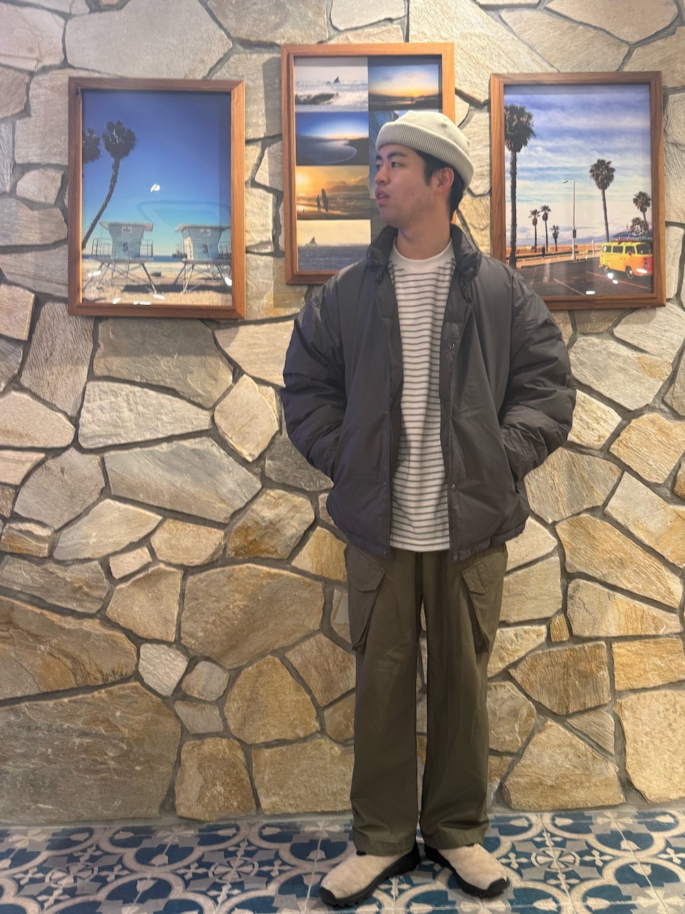 グレー系のダウンジャケット/コート、グリーン系のその他パンツ、ホワイト系のTシャツ/カットソーを着用したメンズの冬コーディネートの2枚目の写真