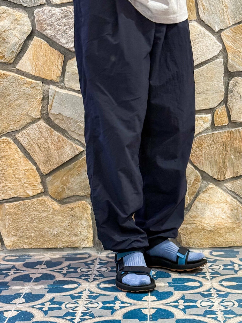 ブルー系のその他パンツ、グレー系のTシャツ/カットソー、ブラック系のサンダルを着用したメンズの春コーディネートの3枚目の写真