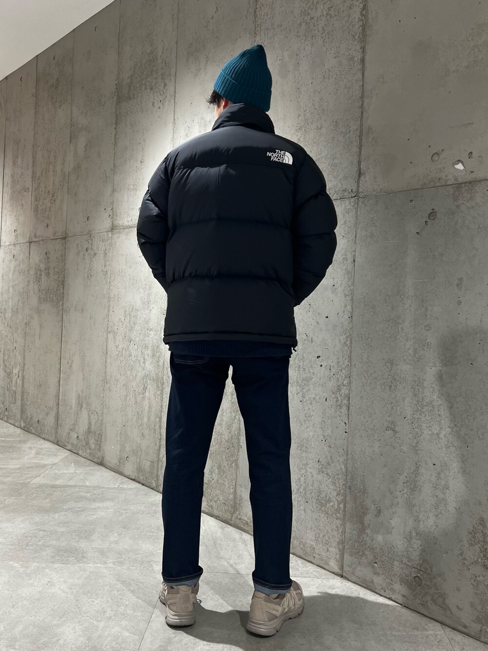 ブラック系のダウンジャケット/コート、ブルー系のその他パンツ、グリーン系のニットキャップ/ビーニーを着用したメンズの冬コーディネートの2枚目の写真