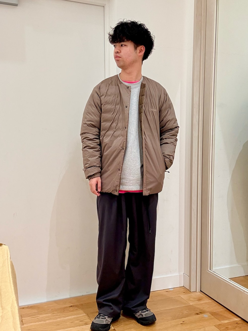 ブラウン系のダウンジャケット/コート、グレー系のその他パンツ、グレー系のスニーカーを着用したメンズの秋コーディネートの2枚目の写真