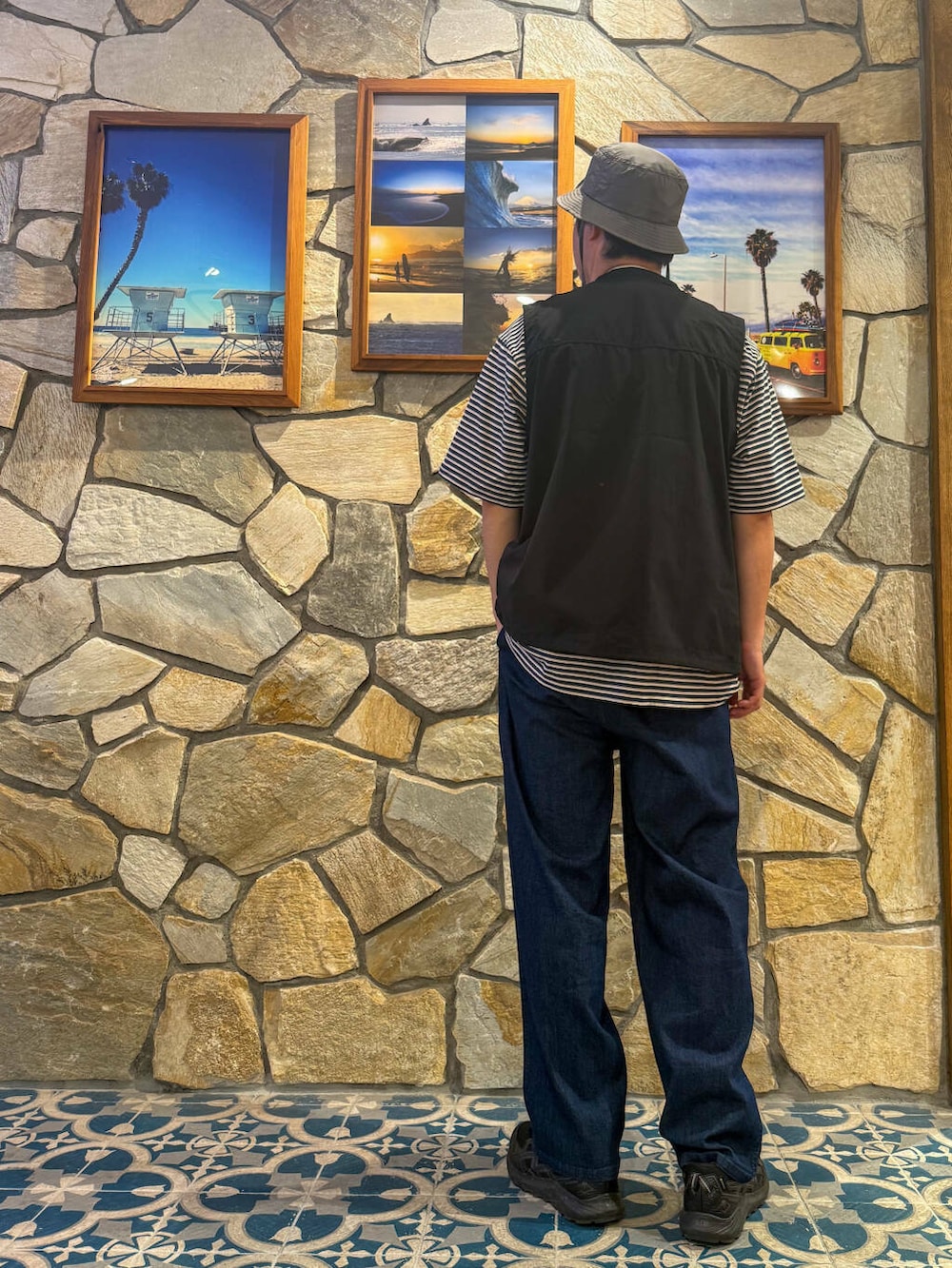 ブラック系のベスト、ベージュ系のショルダーバッグ、ブルー系のその他パンツを着用したメンズの春コーディネートの4枚目の写真