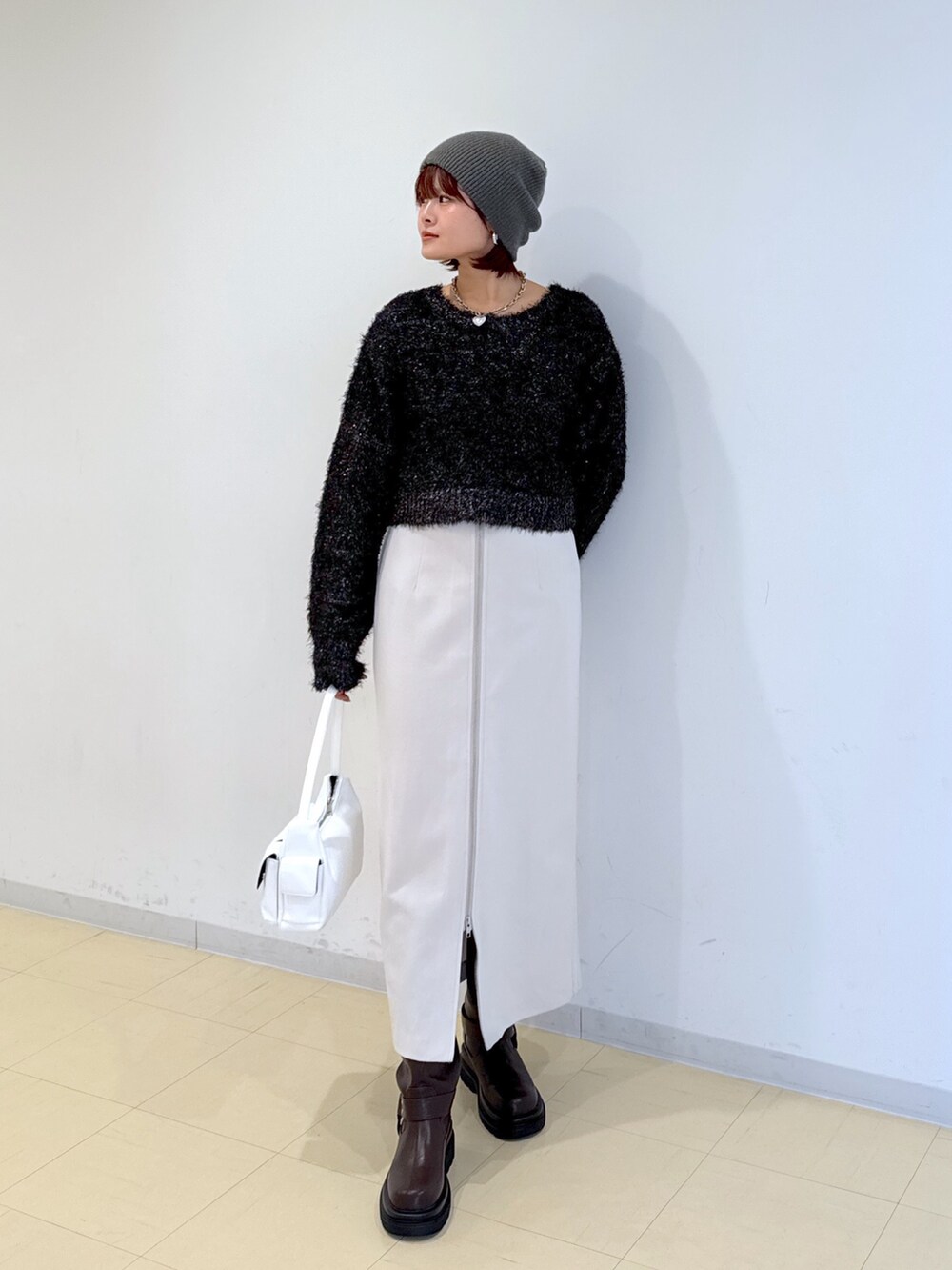 グリーン系のブルゾン、ホワイト系のハンドバッグ、ブラウン系のブーツを着用したレディースの冬コーディネートの5枚目の写真