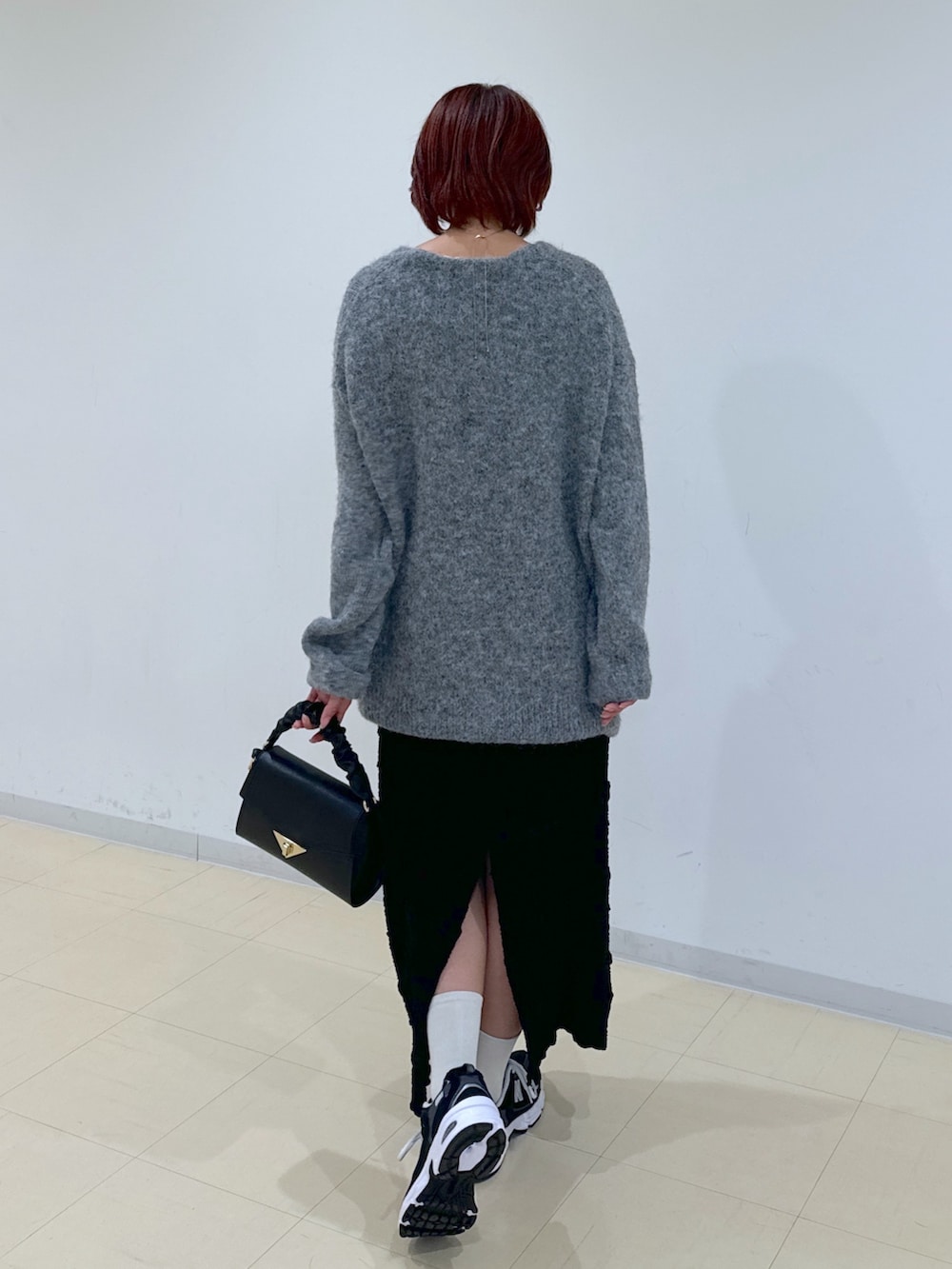 グレー系のカーディガン/ボレロ、ブラック系のスカート、ブラック系のショルダーバッグを着用したレディースの秋コーディネートの3枚目の写真