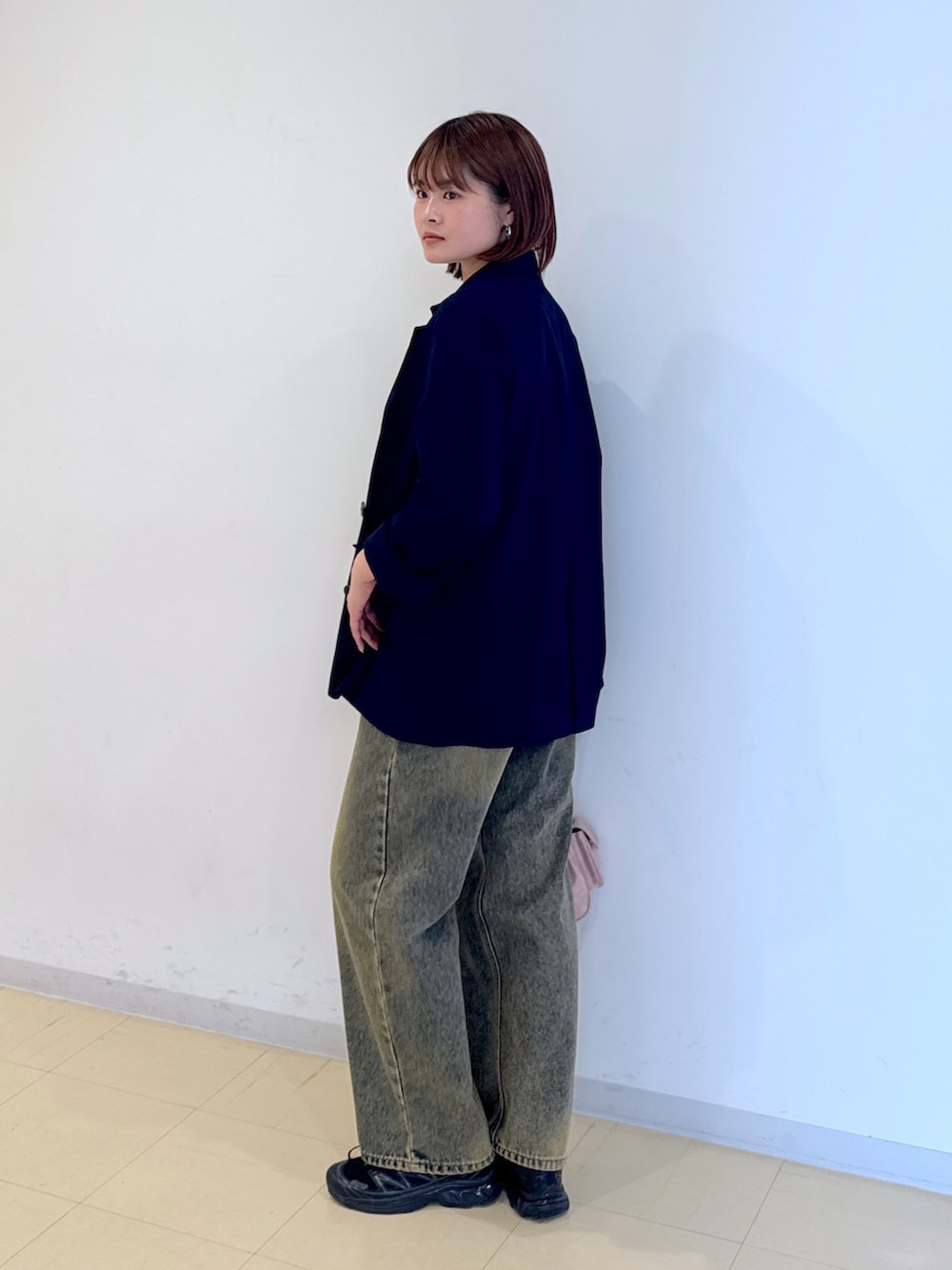 ピンク系のショルダーバッグ、ブルー系のデニムパンツ、ホワイト系のTシャツ/カットソーを着用したレディースの春コーディネートの2枚目の写真