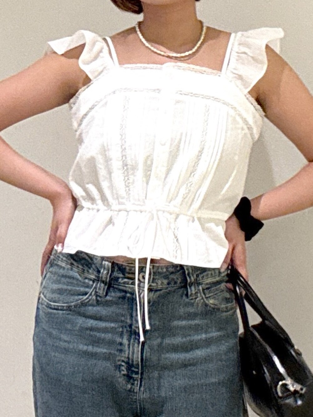 ブルー系のデニムパンツ、ブラック系のトートバッグ、ホワイト系のシャツ/ブラウスを着用したレディースの夏コーディネートの3枚目の写真