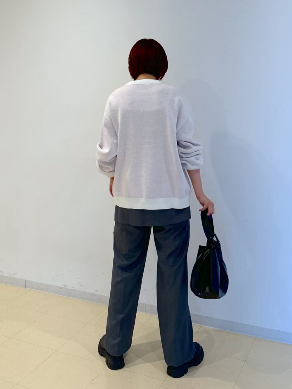 グレー系のその他パンツ、ブラック系のハンドバッグ、ゴールド系のネックレスを着用したレディースの秋コーディネートの3枚目の写真