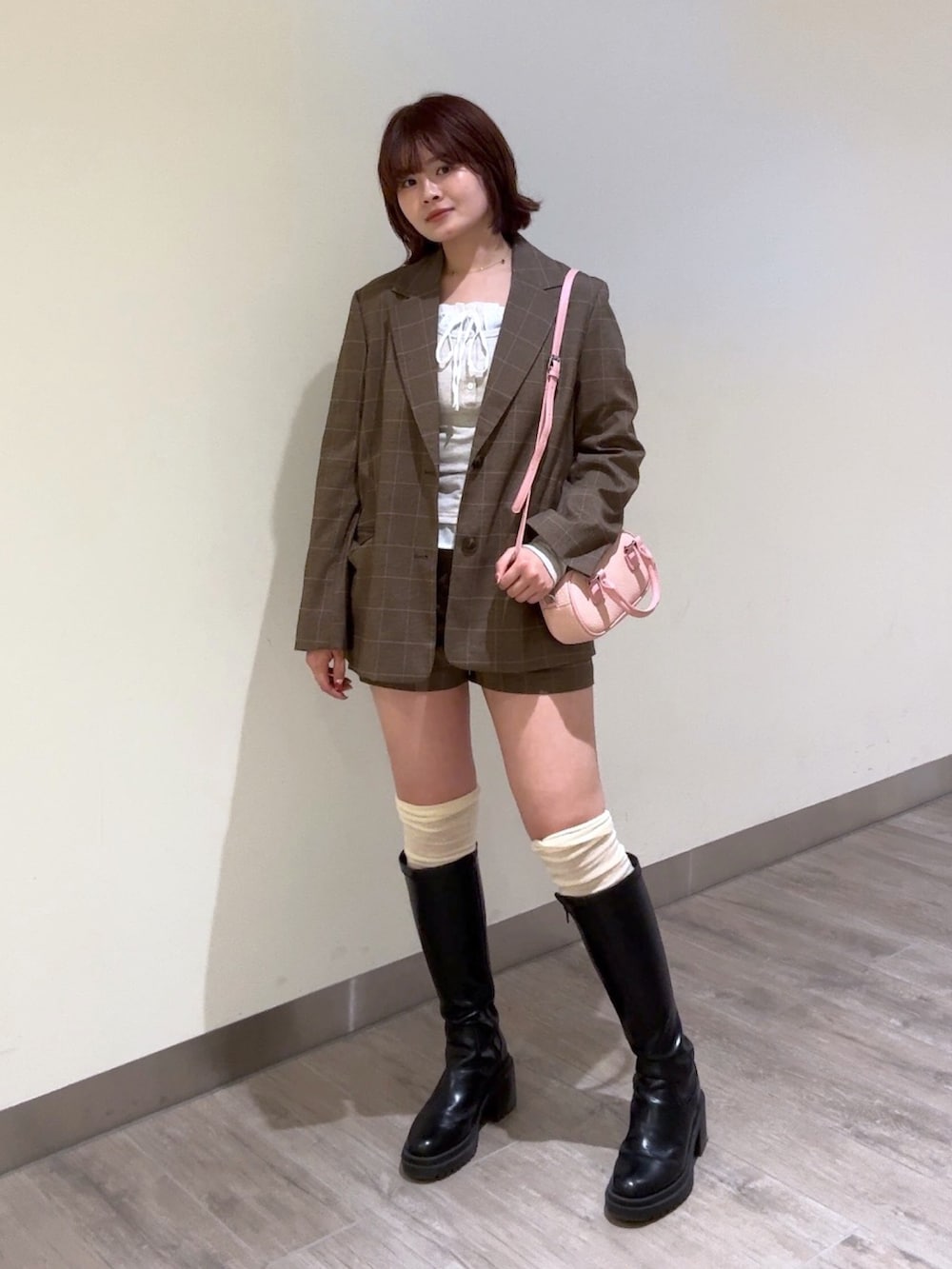 ブラウン系のテーラードジャケット、ブラウン系のその他パンツ、ピンク系のボストンバッグを着用したレディースの冬コーディネートの3枚目の写真