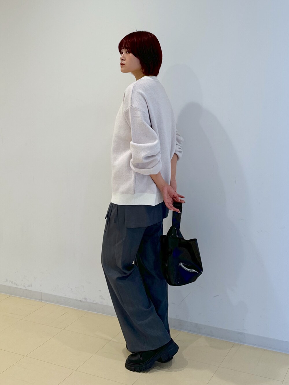 グレー系のその他パンツ、ブラック系のハンドバッグ、ゴールド系のネックレスを着用したレディースの秋コーディネートの5枚目の写真