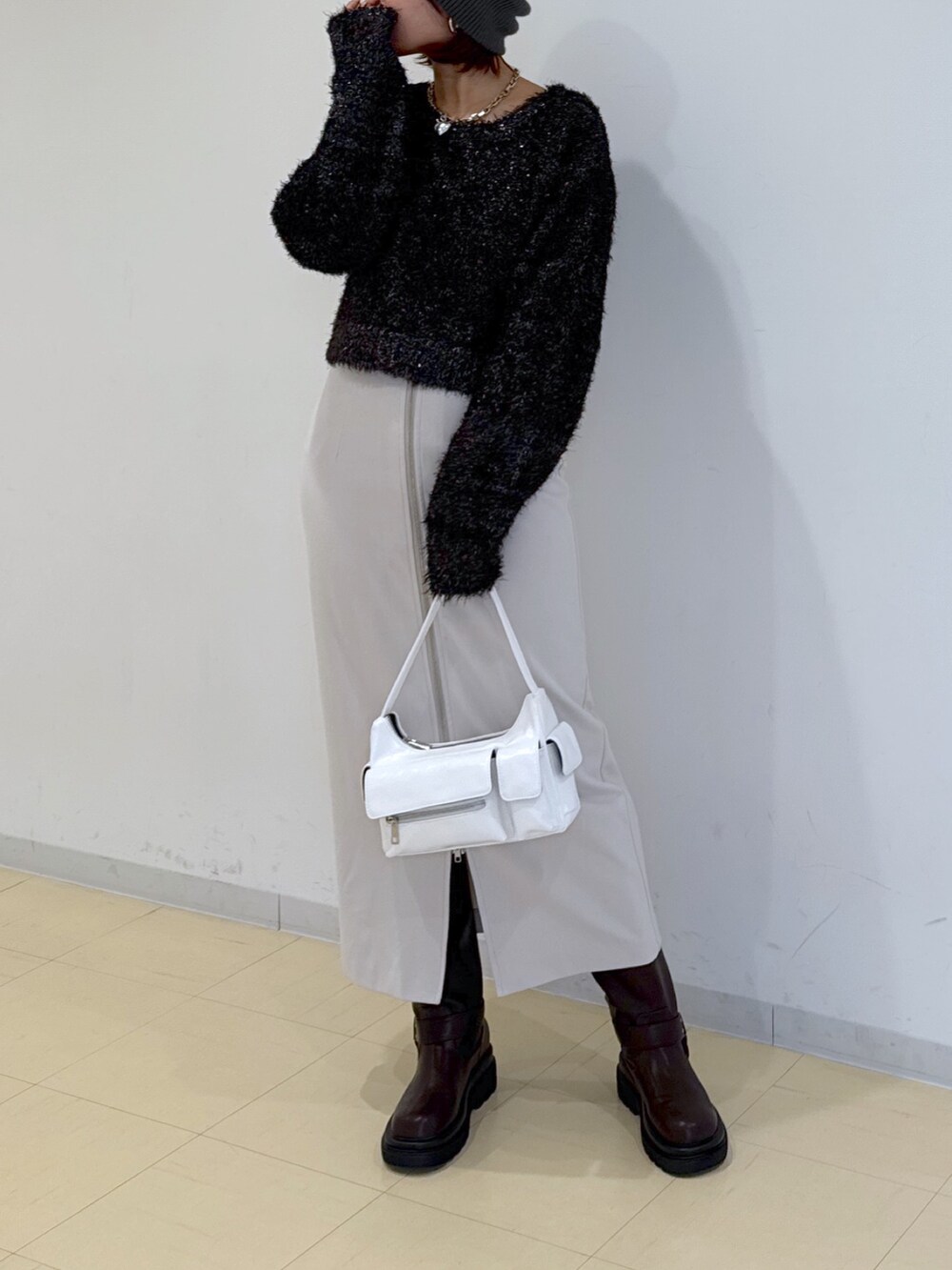 グリーン系のブルゾン、ホワイト系のハンドバッグ、ブラウン系のブーツを着用したレディースの冬コーディネートの7枚目の写真