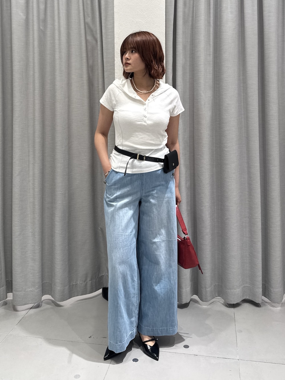 ブルー系のデニムパンツ、ホワイト系のTシャツ/カットソー、レッド系のショルダーバッグを着用したレディースの夏コーディネートの2枚目の写真