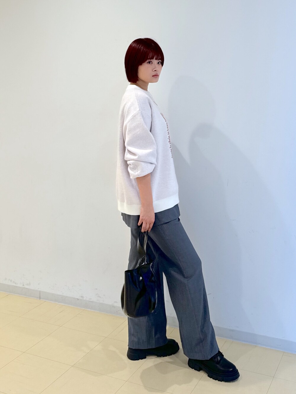 グレー系のその他パンツ、ブラック系のハンドバッグ、ゴールド系のネックレスを着用したレディースの秋コーディネートの4枚目の写真