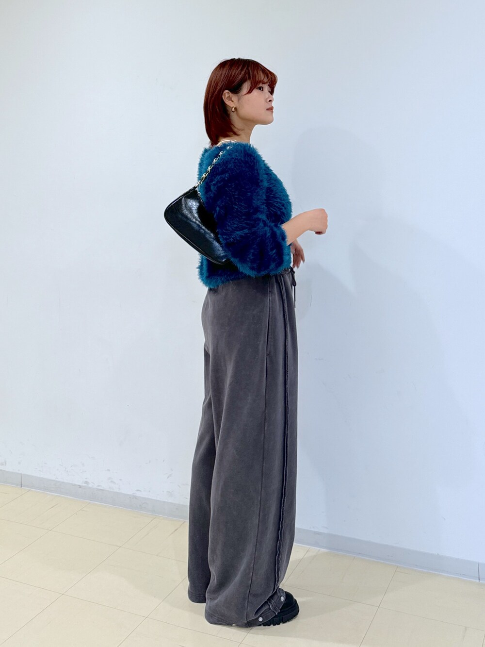 ブラック系のブーツ、グリーン系のカーディガン/ボレロ、ブラック系のトートバッグを着用したレディースの秋コーディネートの3枚目の写真